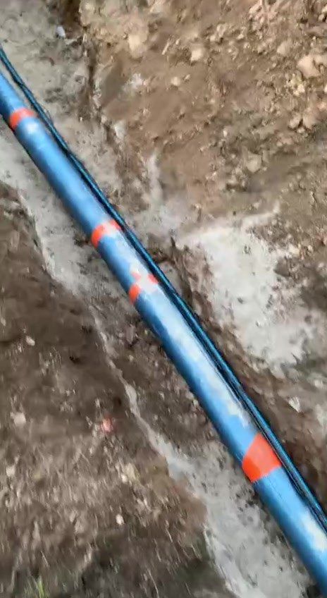 Modré potrubí s oranžovými páskami v dlouhé rýze