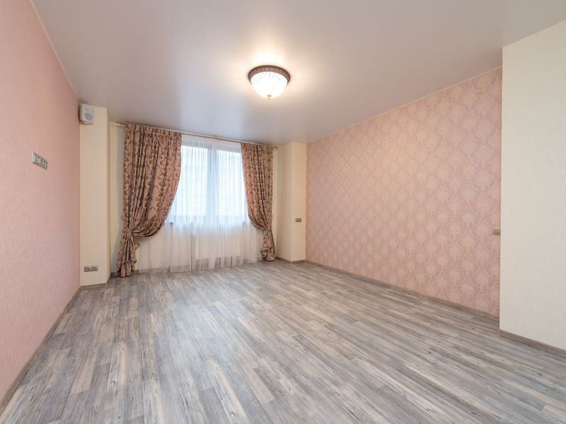 Prázdný pokoj s novou podlahou a vymalovanými stěnami